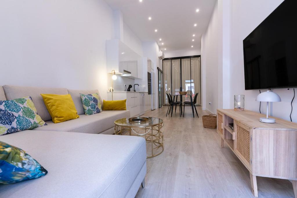 a living room with a white couch and a tv at Apartamento moderno recién reformado con patio en el centro de Elche in Elche
