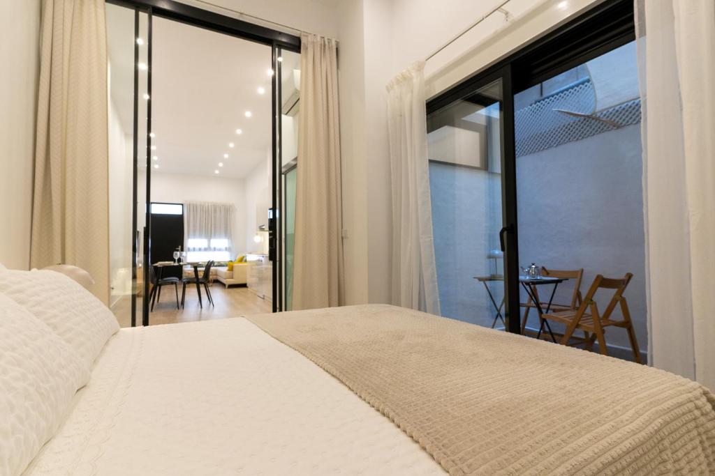a bedroom with a bed and a sliding glass door at Loft moderno recién reformado con patio en el centro de Elche in Elche
