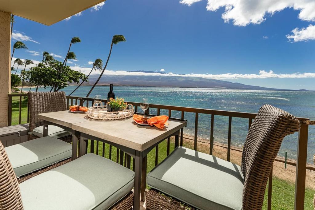 a table and chairs on a balcony overlooking the ocean at Kanai A Nalu 202 in Wailuku