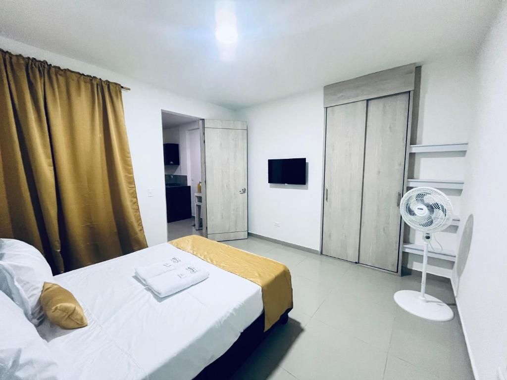 a hotel room with a bed and a fan at Habitacion con baño privado cali in Cali
