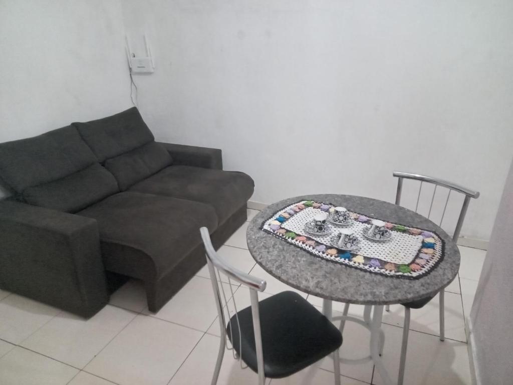 een woonkamer met een bank, een tafel en stoelen bij Casa independente e aconchegante in Poços de Caldas