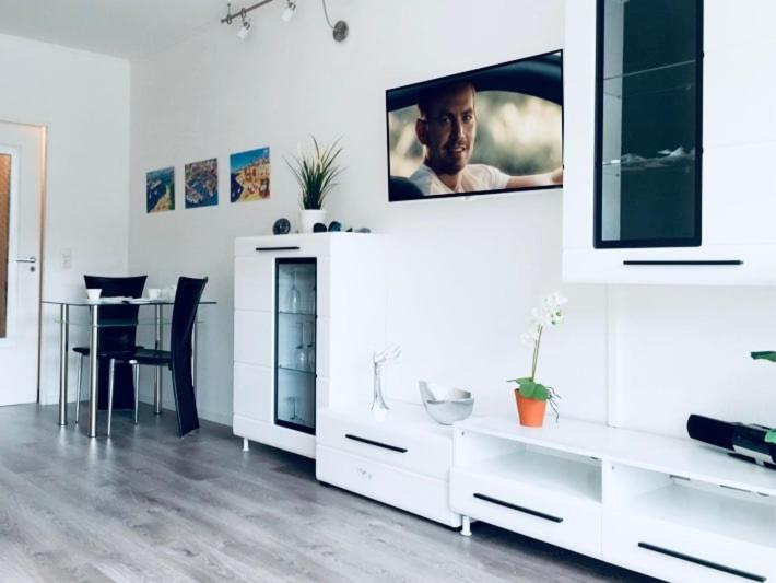 a white living room with a tv on a wall at Sealine Laboe in Laboe