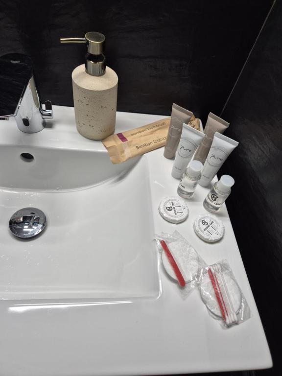 a white bathroom sink with various items on it at Olive Ultracentral Craiova in Craiova