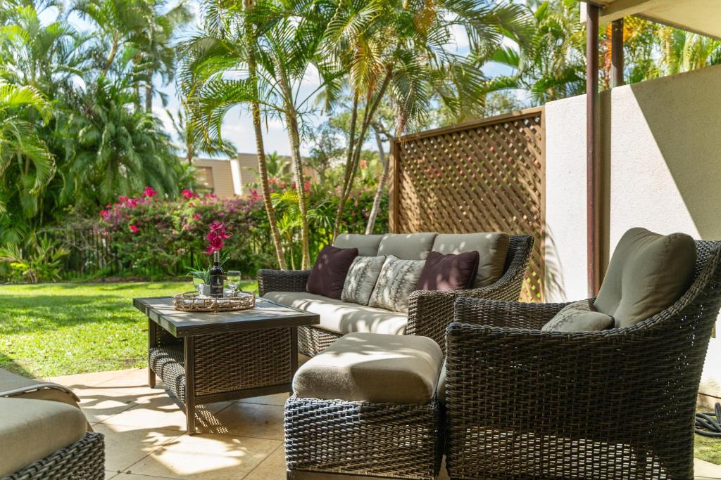 a patio with a couch and chairs and a table at Maui Kamaole K104 in Wailea