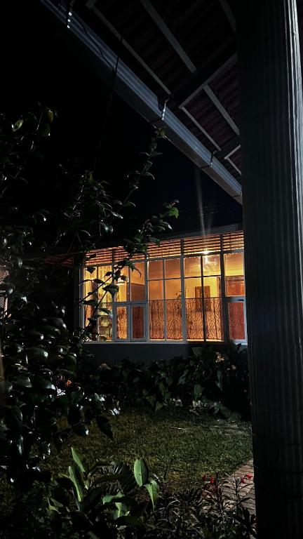 a building with a lit up window at night at Massbungalow in Tindummal