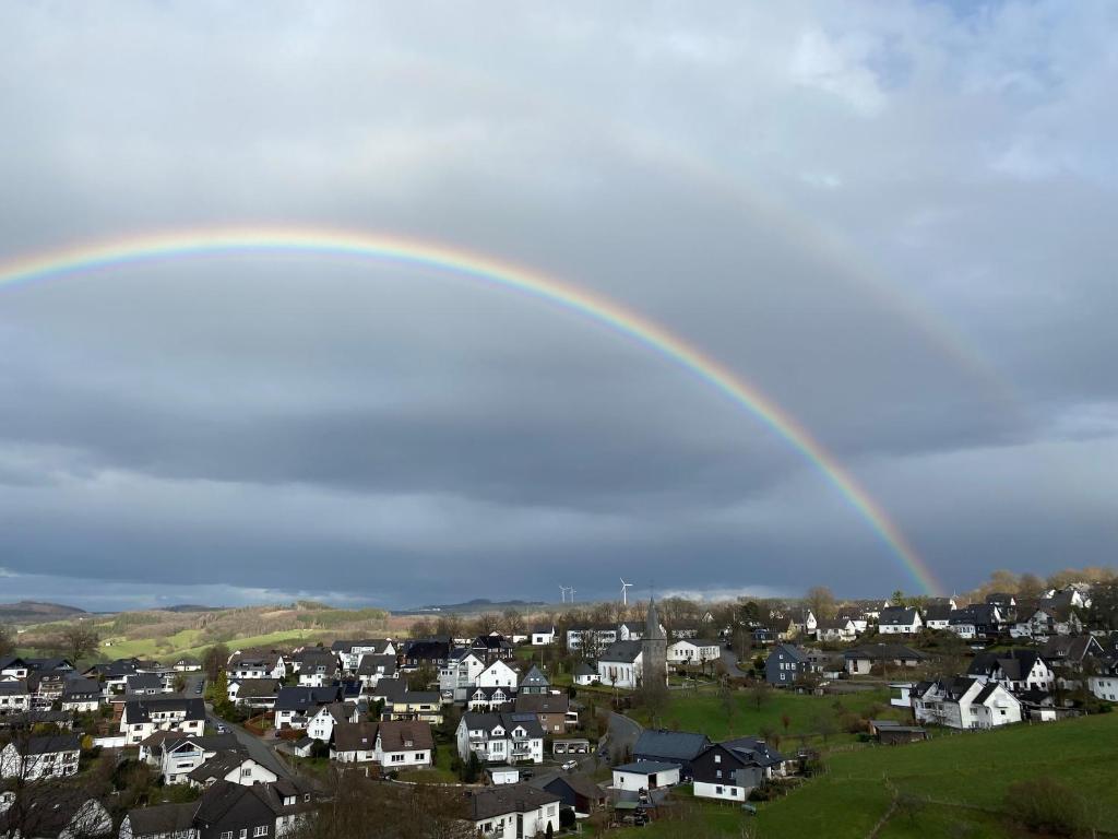 Ferienwohnung Auszeit am Waldrand في أولبه: قوس قزح في السماء فوق مدينة بها بيوت