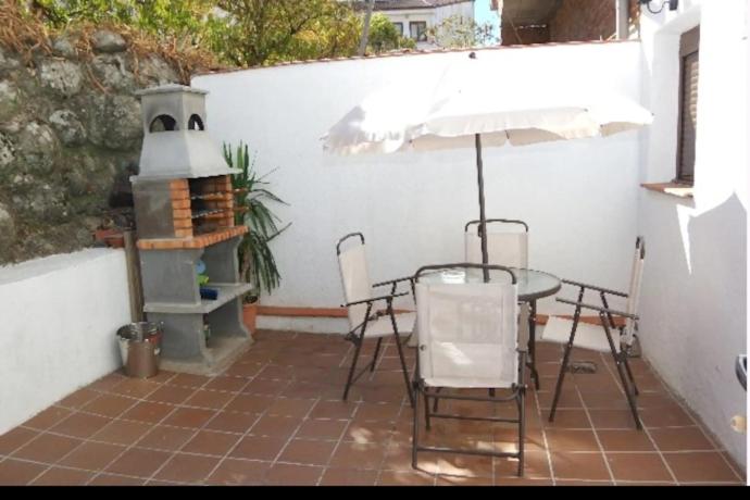 Refugio tranquilo cerca de las piscinas في كانديليدا: فناء مع طاولة وكراسي وسخان