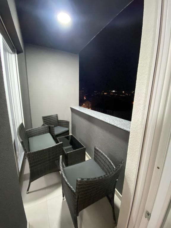 Zimmer mit Stühlen und einem Balkon mit Aussicht in der Unterkunft L Apartaments in Peja