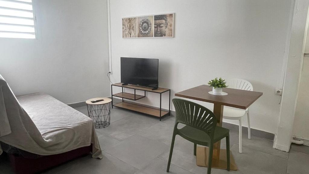 Zen and cozy escape between sea, mountain and river في بوانت-نوار: غرفة معيشة فيها سرير وطاولة وتلفزيون