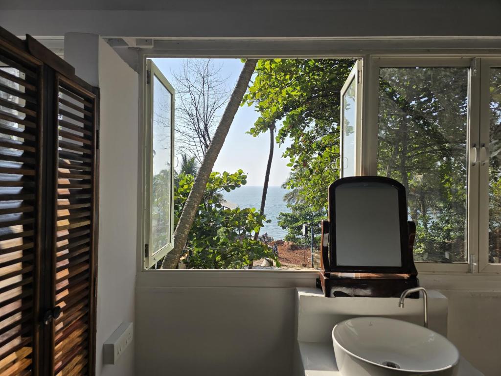 a room with a chair and a window at Beachside in Anjuna