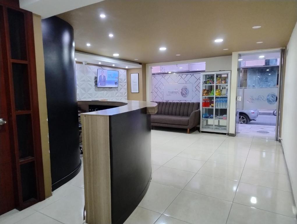 a lobby with a bar with a couch in the background at Hotel Rialto Suite in Pasto