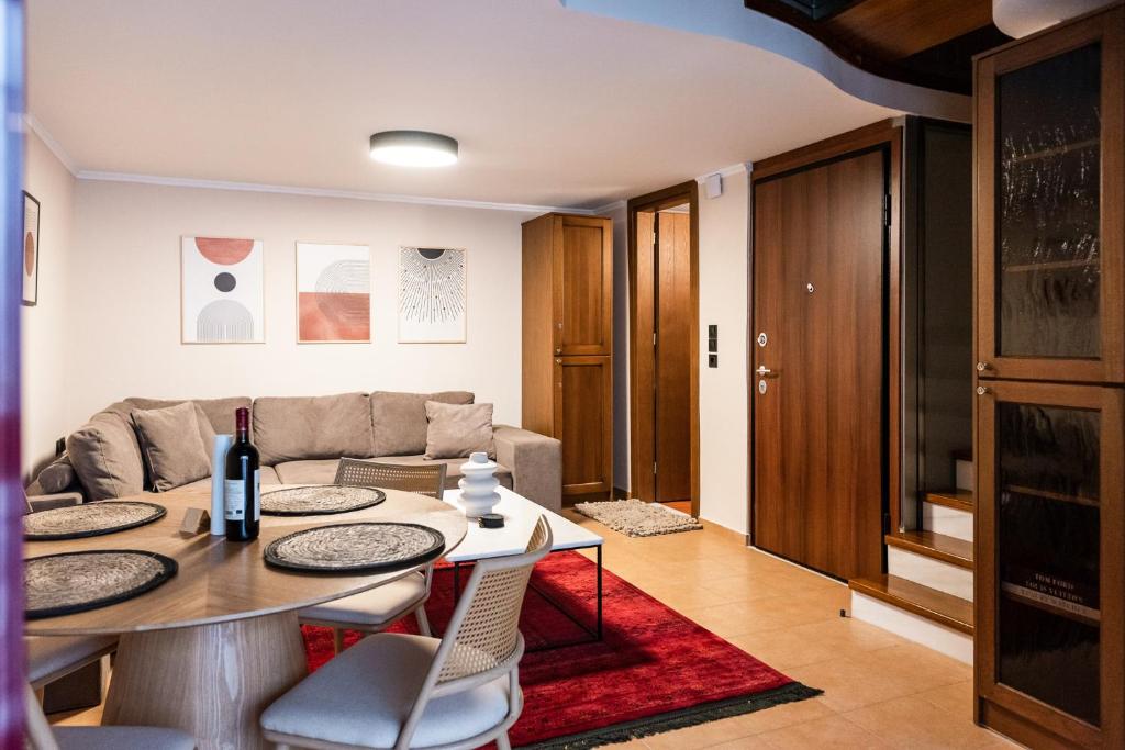 Tollmere Hospitality Λύχνος suite في ليفاديا: غرفة معيشة مع طاولة وأريكة