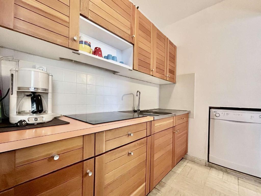een keuken met houten kasten en een aanrechtblad bij Appartement lumineux 2 pièces + coin montagne, 6 couchages, proche commerces et pistes - Monêtier-les-Bains - FR-1-330F-32 in Le Monêtier-les-Bains
