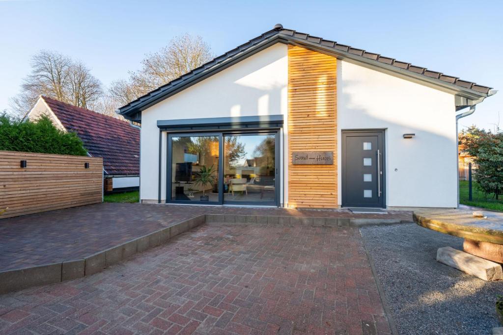 a house with a large glass door and a patio at Sund Huus in Altefähr