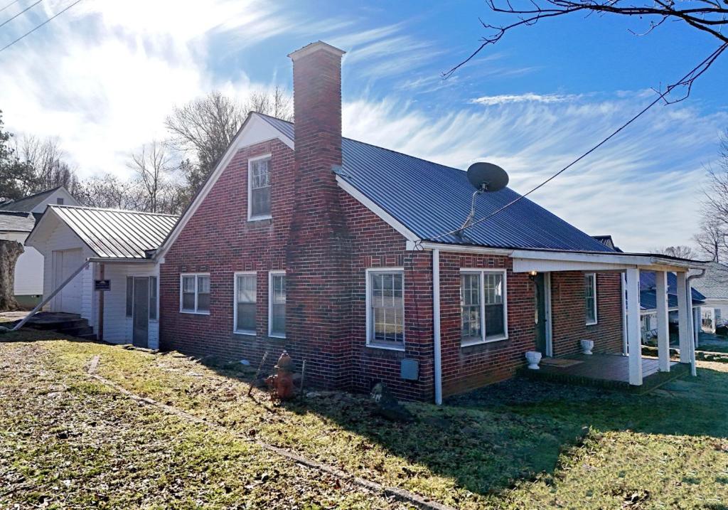 una casa in mattoni rossi con un camino di The Copper Cottage on Main ad Abbeyville