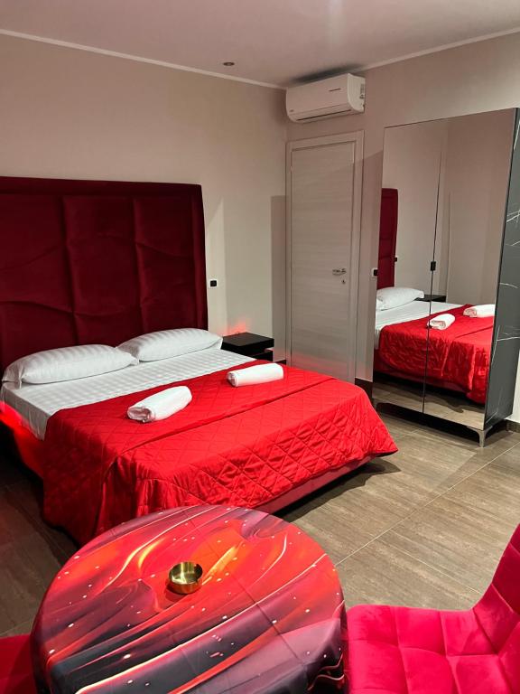 Habitación de hotel con 2 camas y manta roja en Hotel Iris, en Varcaturo