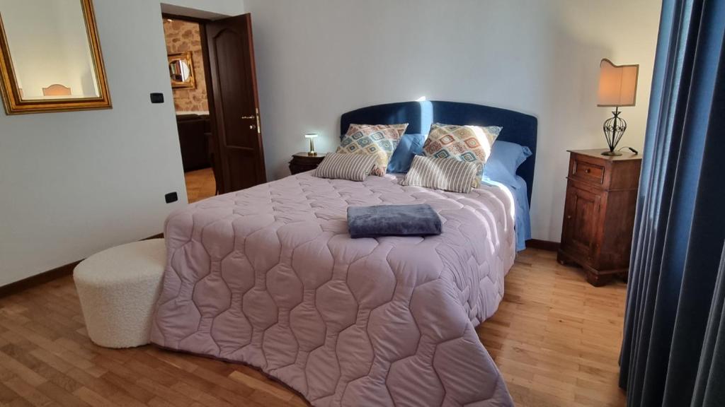 a bedroom with a large bed with a purple comforter at Assisi - Appartamento Maristella in Santa Maria degli Angeli