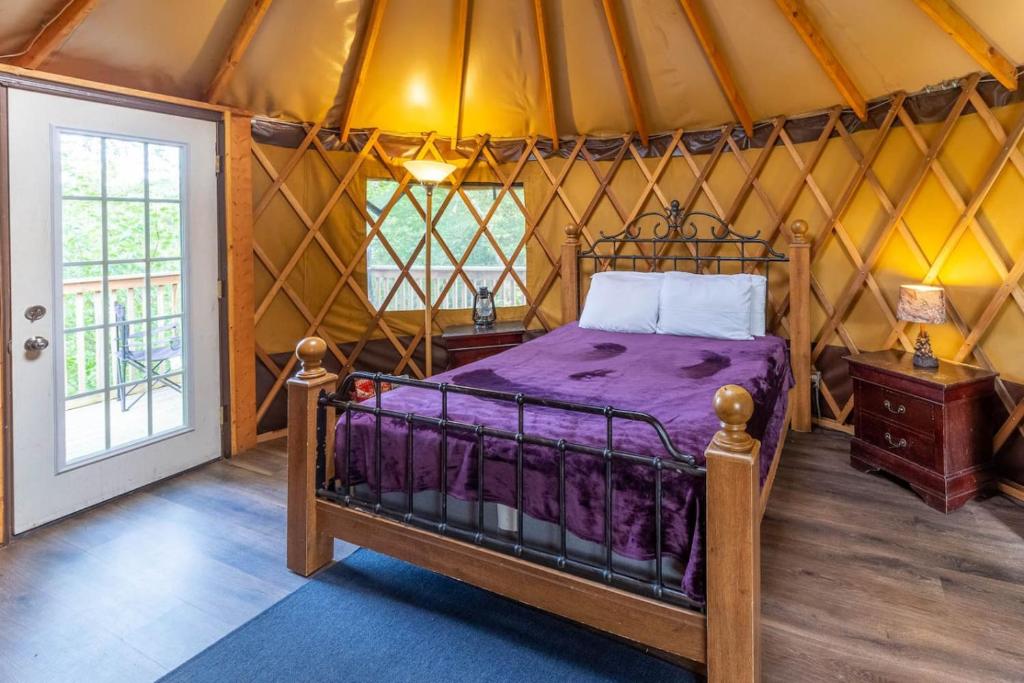 een slaapkamer met een bed in een yurt bij Summerset Ridge - 100 Acre Reserve, River Access, and Endless Adventure! in Cullowhee