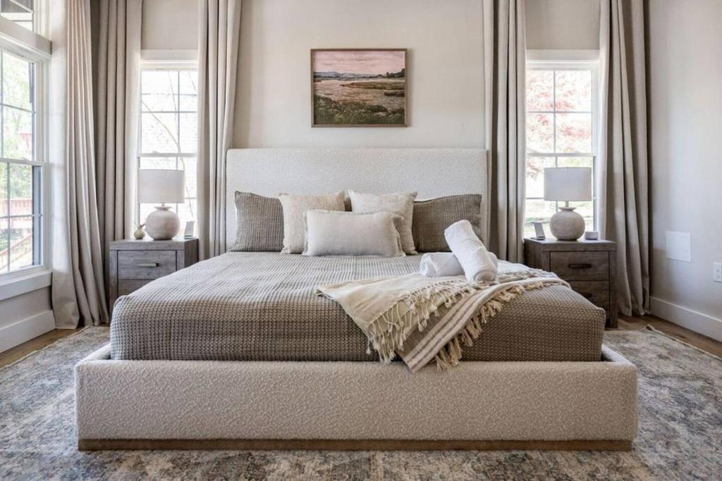 een slaapkamer met een groot bed en 2 ramen bij Bass Cove - Luxury Lakefront, Hot Tub, Fire Table & Theatre! in Kasey