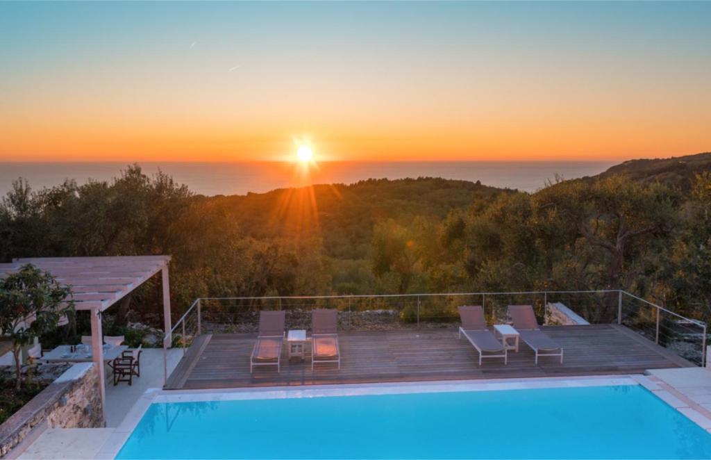 a villa with a swimming pool and a sunset at Kallista House in Kourtaíïka