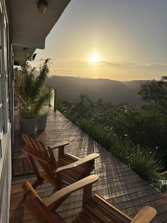 a deck with two chairs and a view of the mountains at Suites da Dani in Areal