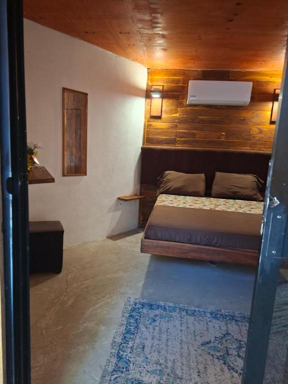 Un dormitorio con una cama y una pared de madera. en Las cabañas duo, en Tulum