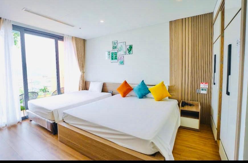 Flamingos Hải Tiến -view biển في Gò Ba Quần: غرفة نوم بها سريرين ونافذة كبيرة