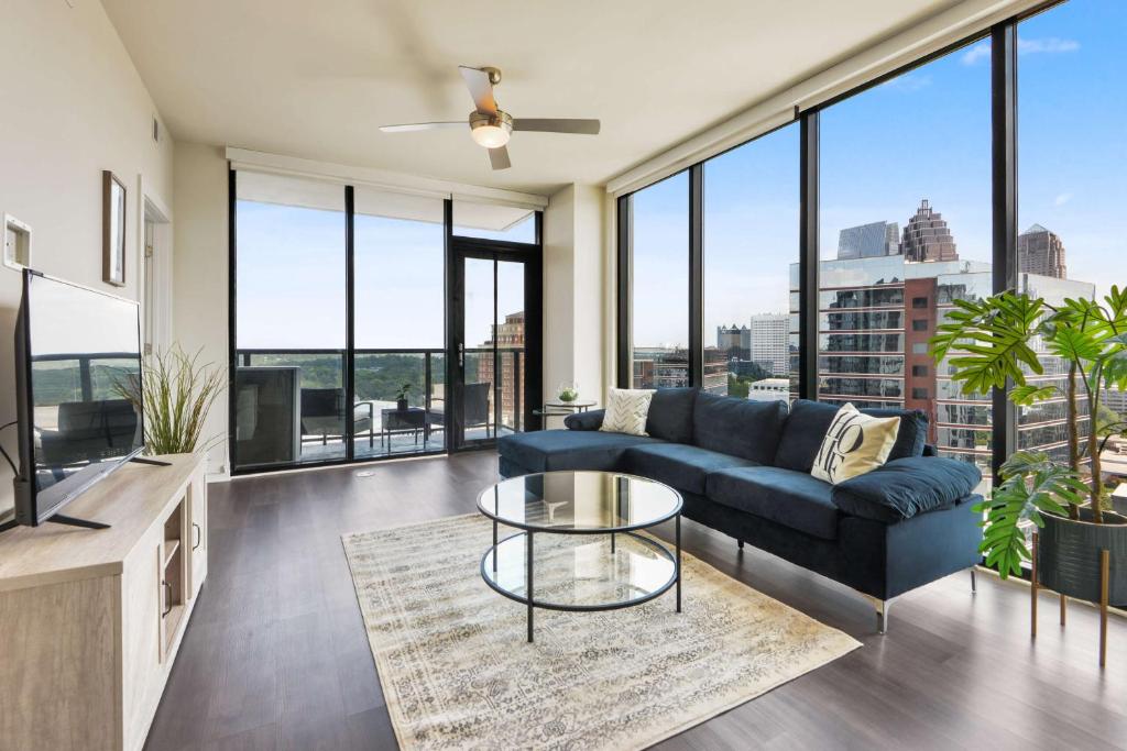 a living room with a blue couch and a glass table at Amazing Midtown 2 bdrm in Atlanta
