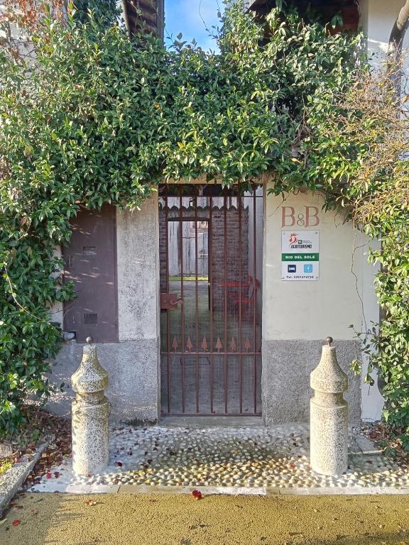 a gate in front of a building with ivy at Tenuta Rio del Sole-Appartamento in Albairate