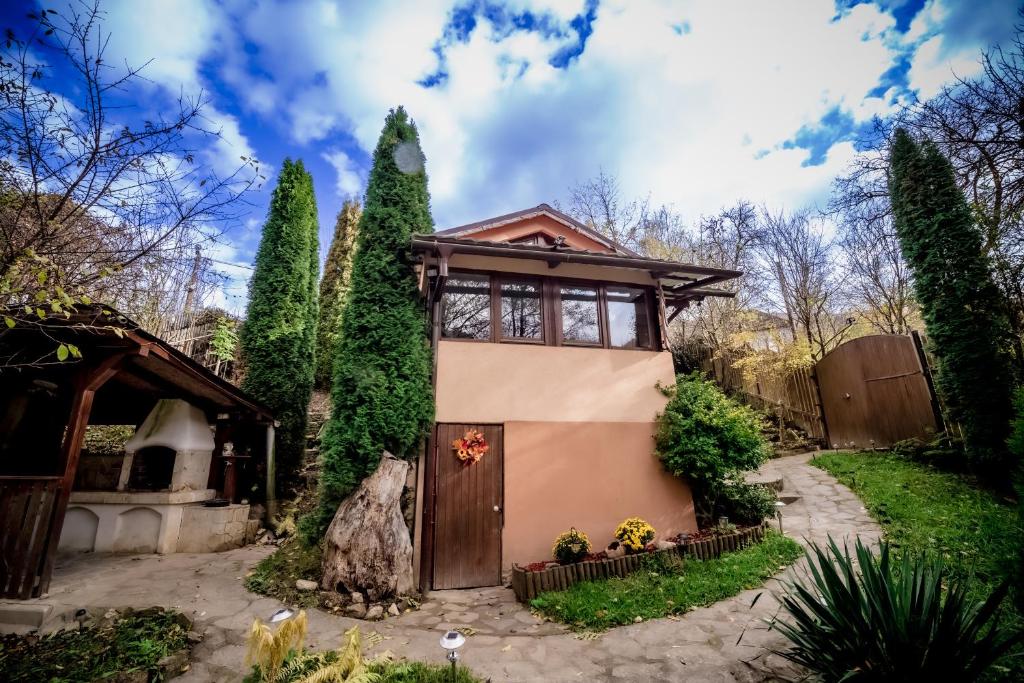 een huis met een deur in een tuin bij Green Hideaway in Fîntînele