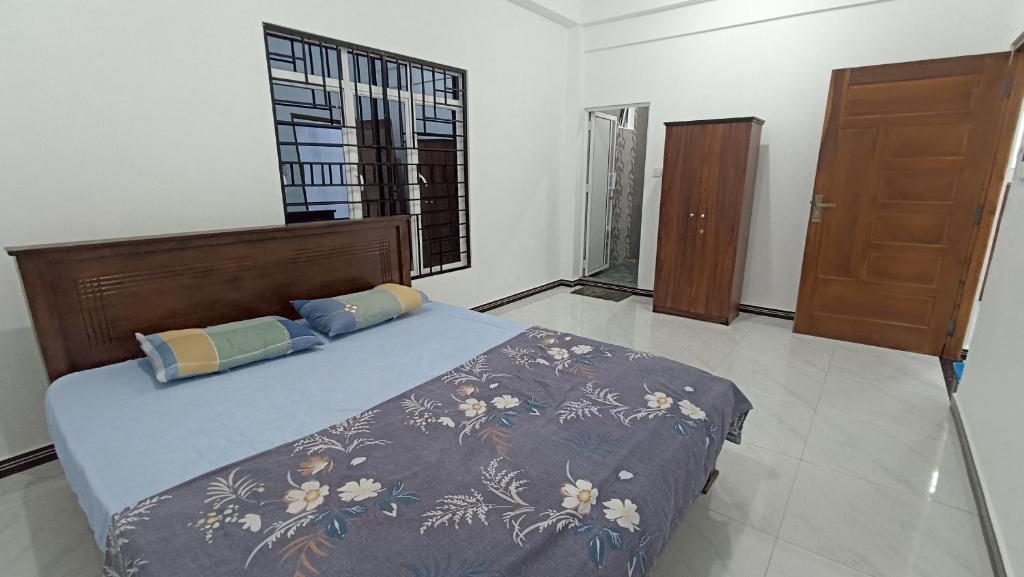 Un dormitorio con una cama grande y una ventana. en APV Home, en Trincomalee