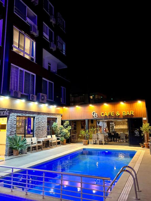ein Schwimmbad vor einem Gebäude bei Nacht in der Unterkunft Cemal Bey Hotel in Alanya