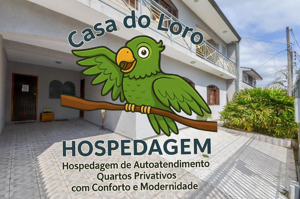 Casa do Loro Hospedagem في كوريتيبا: لافتة لمستشفى عليها طائر أخضر يجلس على غصن شجرة