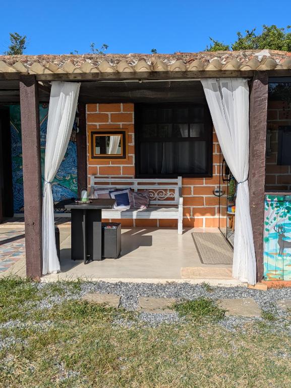 a patio with a bench and a tv on a house at Marina Beach Guest House in Búzios