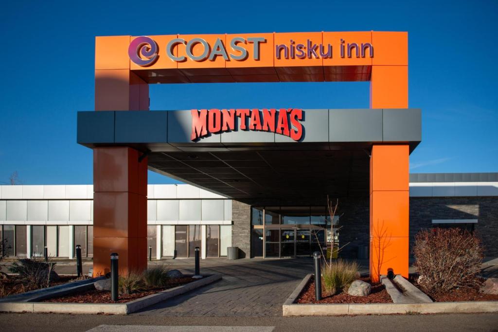 Coast Nisku Inn & Conference Centre في نيسكو: لافتة فندق ساحلي داخل مبنى