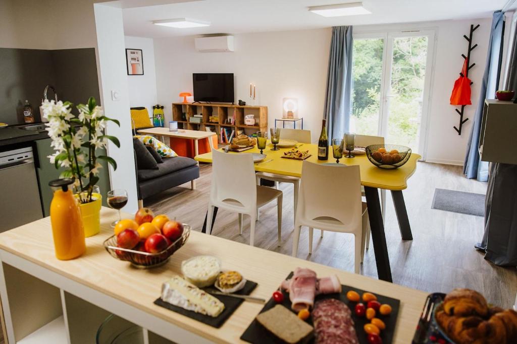 a kitchen and living room with a table with food on it at Appartement rétro nature avec jardin 15 min Toulouse centre in Saint-Geniès-Bellevue