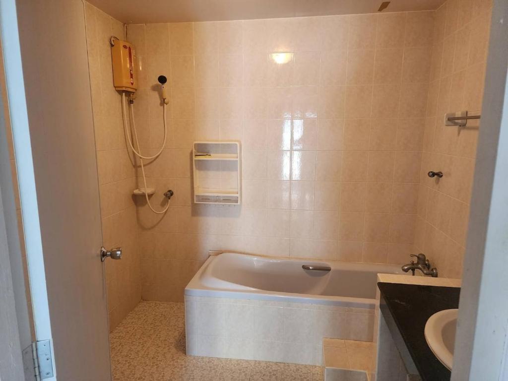a bathroom with a bath tub and a sink at Doze House Patong Phuket in Patong Beach