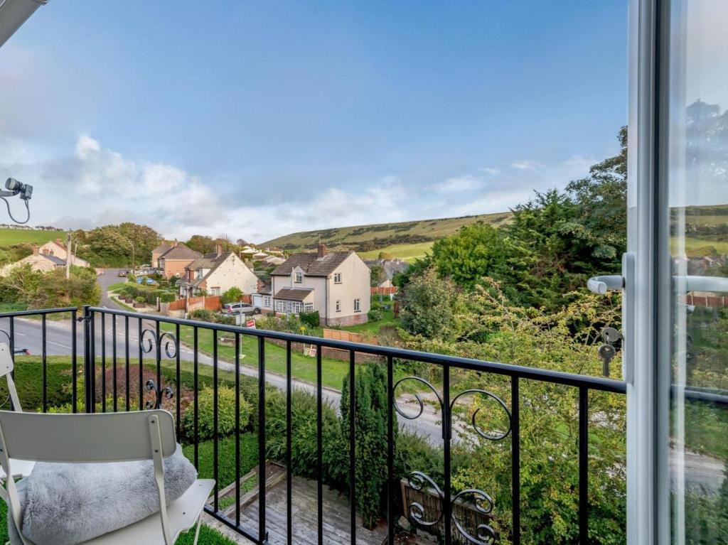 a balcony with a chair and a view of a street at 2 Bed in Wareham oc-79228 in West Lulworth
