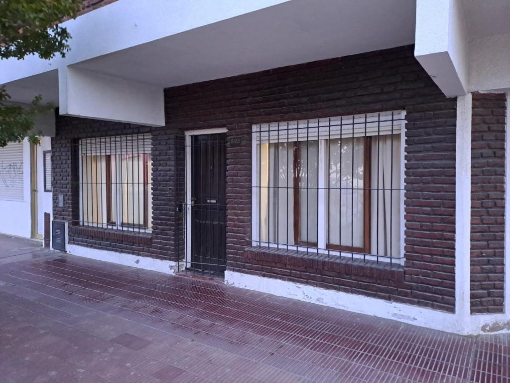 a brick building with barred windows and a door at Nami in Necochea