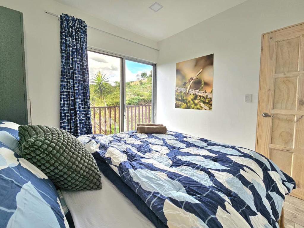 Jardin De Poas Hotel & Nature Resort في Poás: غرفة نوم بها سرير ونافذة