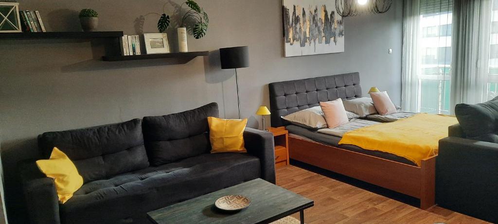 a living room with a couch and a bed at Relax Wellness Apartman in Pusztavacs