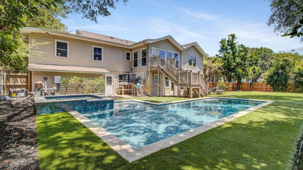 a house with a swimming pool in front of a yard at 11 43rd Avenue by AvantStay Pool Close to Beach in Isle of Palms