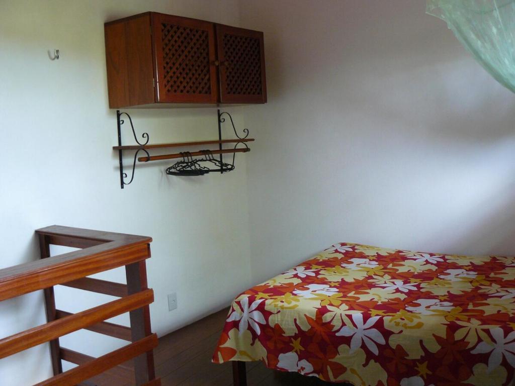 una piccola camera da letto con un letto e una scrivania di Chalé Borboletas Centro Pipa RN a Pipa