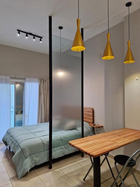 a bedroom with a bed and a table and lights at Monoambiente de diseño in Corrientes