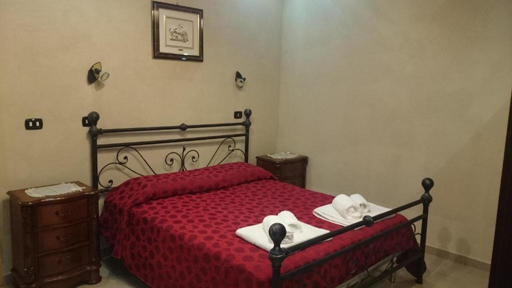una camera da letto con un letto rosso e asciugamani di Fodor ad Avola