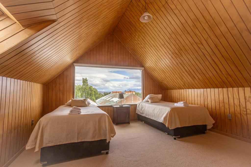 Habitación en el ático con 2 camas y ventana en Lady Florence Dixie, en Puerto Natales