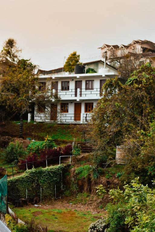 a white house on top of a hill at KSR Aura Homestay in Kodaikānāl