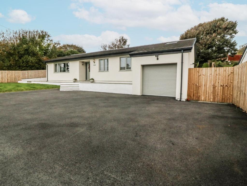 een huis met een garage en een hek bij The Willows in Trearddur
