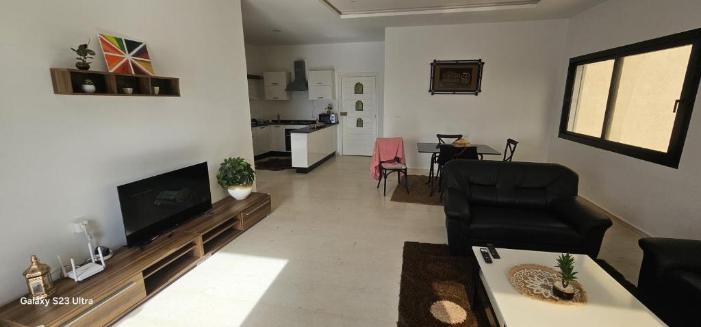 a living room with a tv and a couch and a table at Beach house in Zarzis