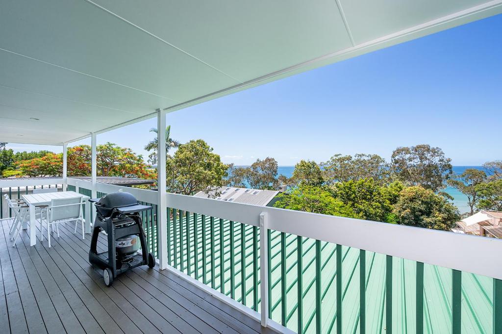 a stroller on a deck with a view of the ocean at Noosa Escape 2BR Ocean Views, Walk to Beach in Noosa Heads